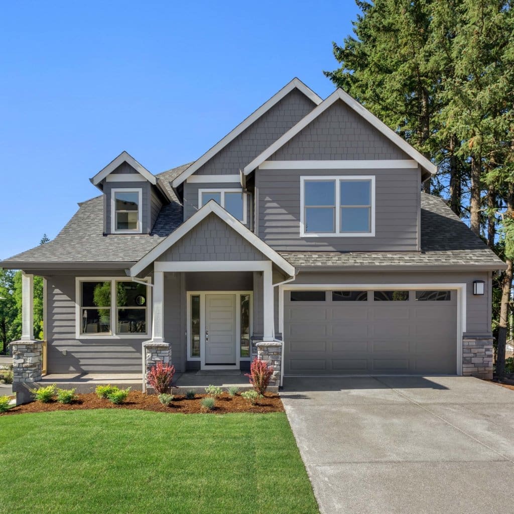 Suburban home exterior on bright sunny day, with large yard and